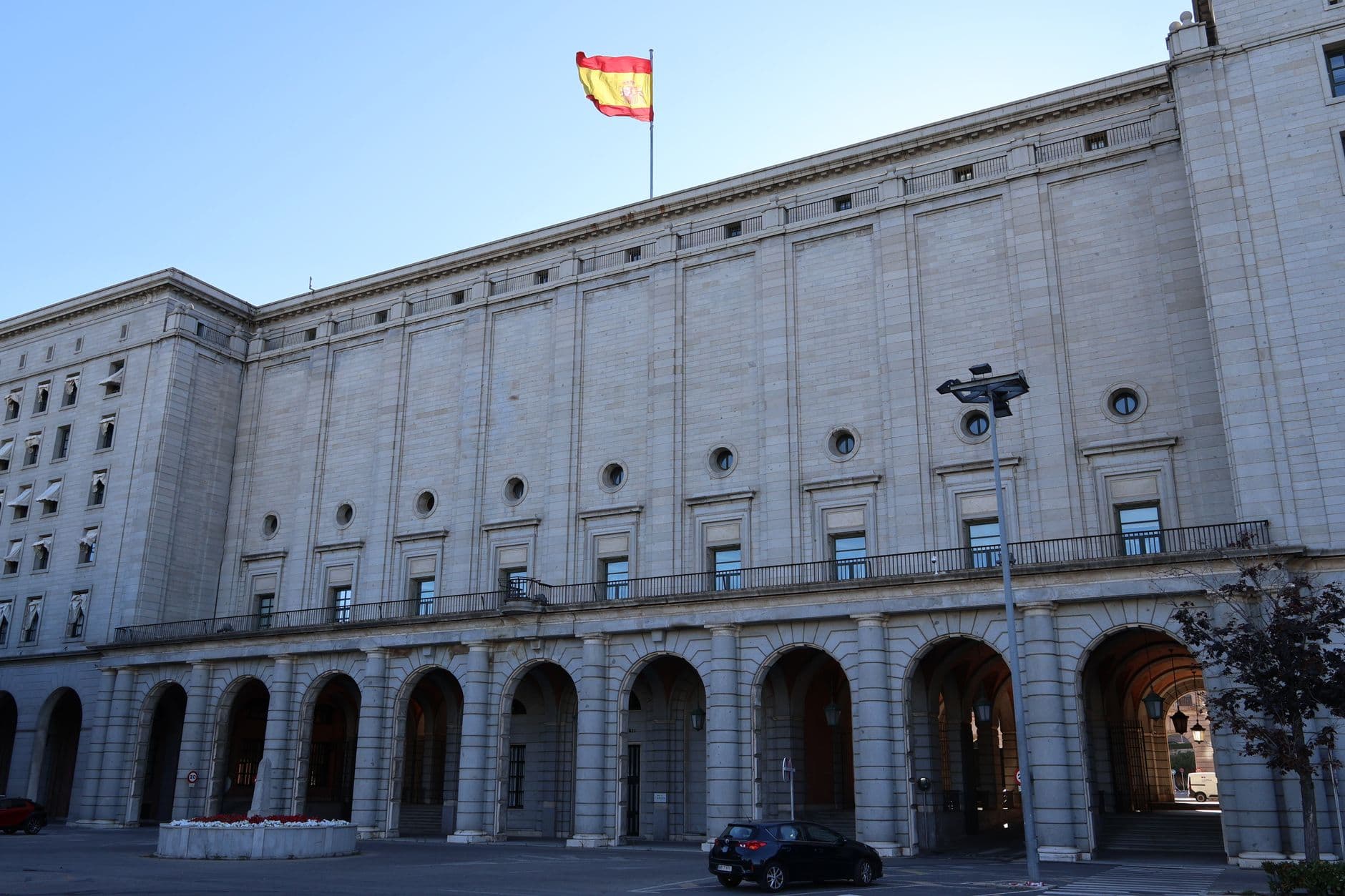 Fachada de un edificio oficial espanol con la bandera de Espana ondeando en la cubierta