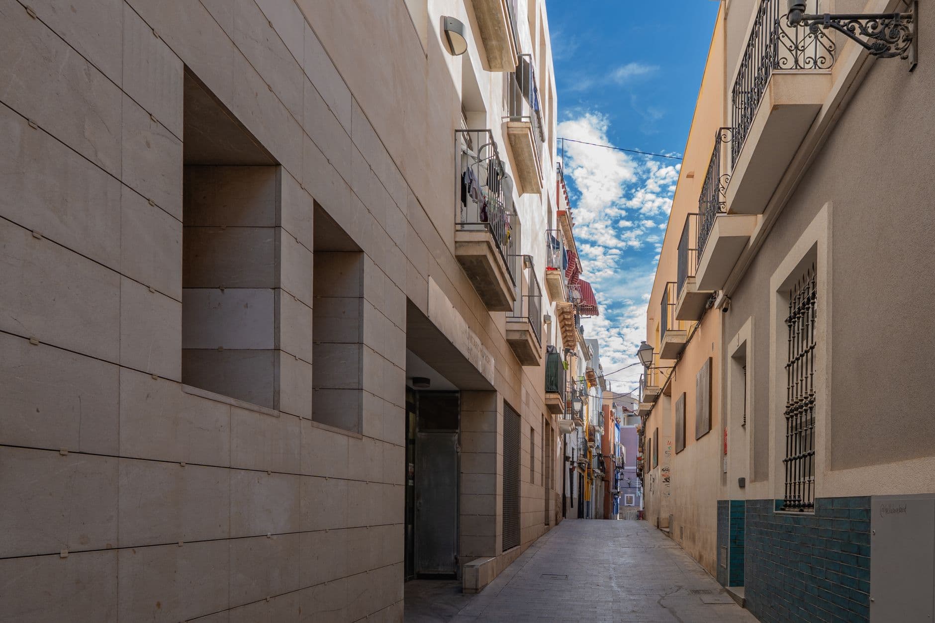 Calle estrecha de un casco antiguo espanol con balcones y ropa tendida