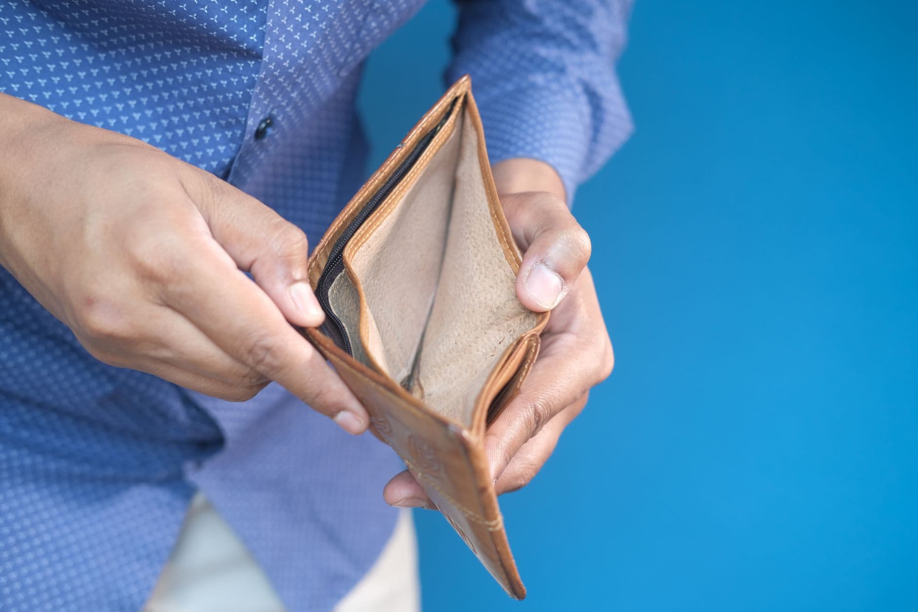 Manos sosteniendo una cartera abierta y vacia