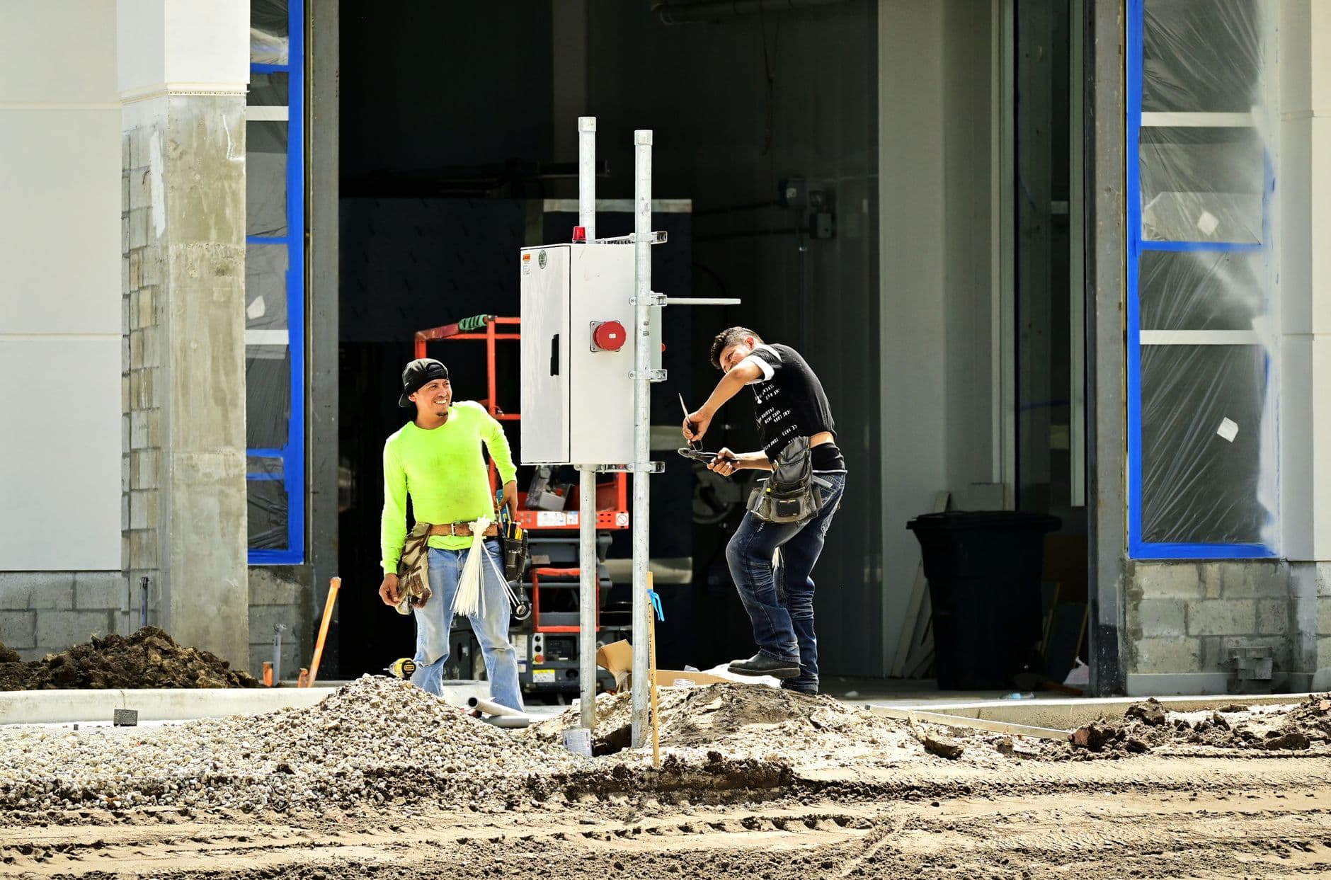 Dos operarios trabajando en la instalacion electrica de una obra