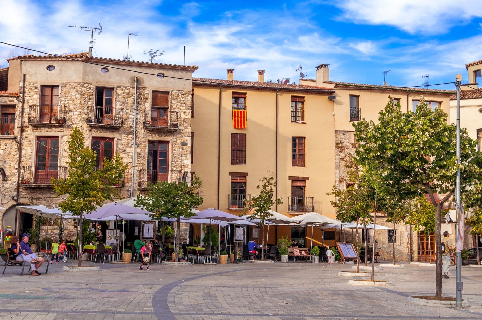 Plaza de un pueblo espanol con terrazas y edificios de piedra